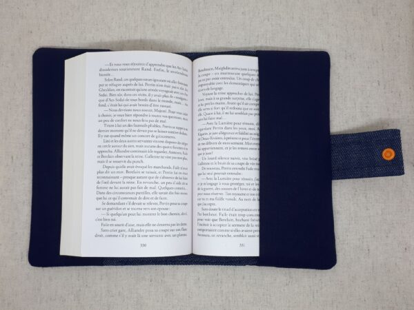 Protège livre en jean et Liberty of London motif Eben, plumes de paon colorées, ouvert avec un livre