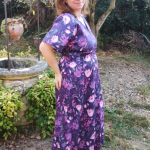 Vue de 3/4 profil droit d'une femme portant la robe longue manches courtes motif fleurs violettes