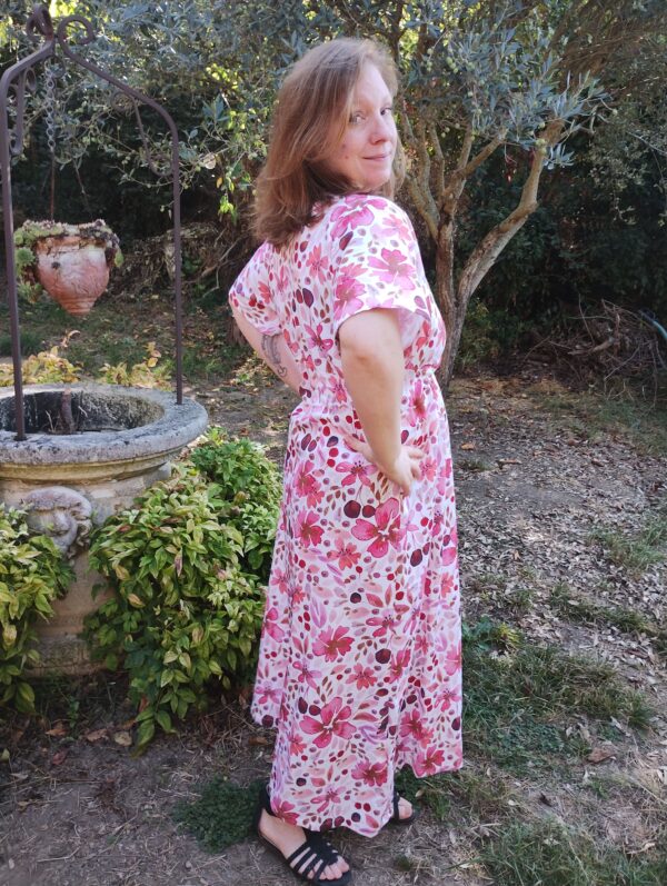 Vue de profil dos de la robe longue manches courtes motif fleurs aquarelles roses portée